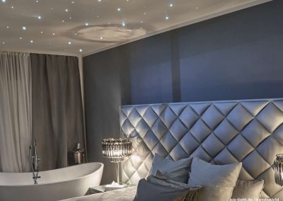 Pix-Light LED‑Sternenhimmel im modernen Schlafzimmer mit kaltweißen Lichtpunkten.